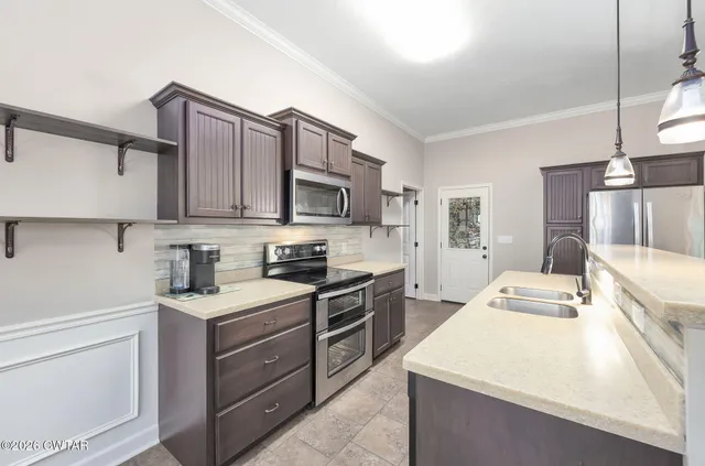 a kitchen with a sink a stove top oven and white cabinets