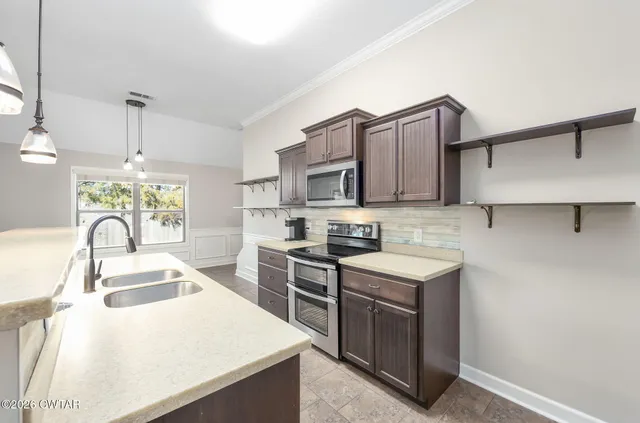 a kitchen with stainless steel appliances granite countertop a sink stove and refrigerator