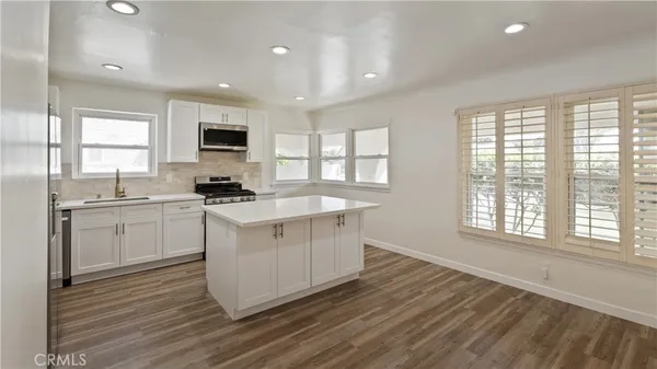 a kitchen with sink a microwave and cabinets