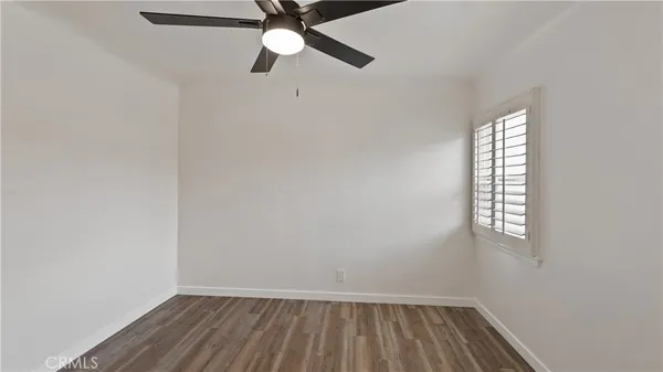 an empty room with a window and ceiling fan