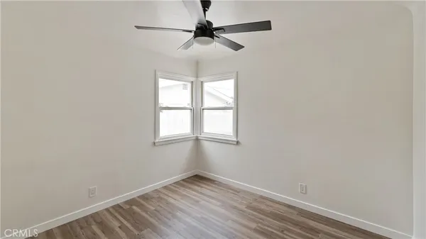 an empty room with a window and a fan