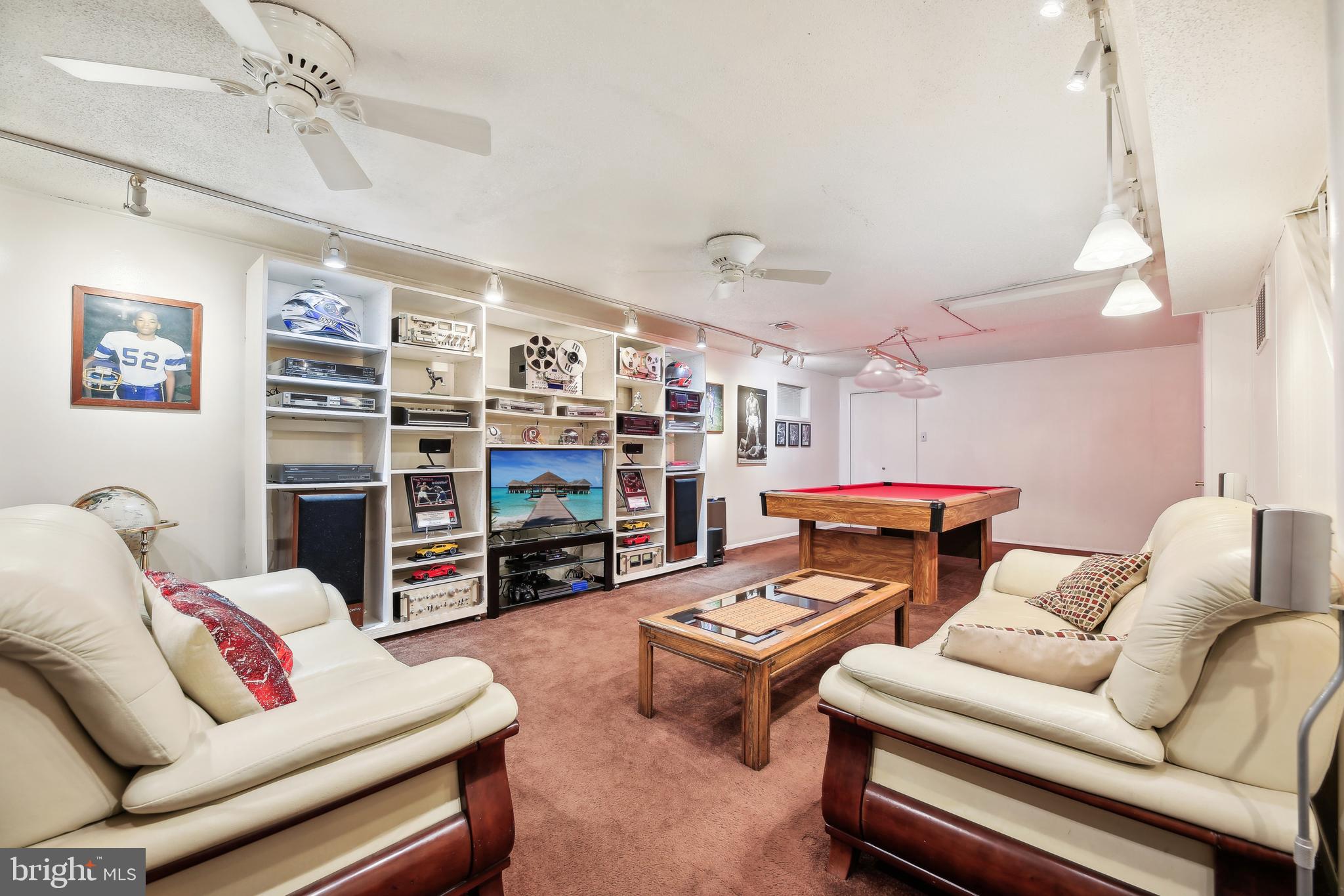8236 Scotts Level Road Pikesville, MD 21208 - Photo 23 of 35 a living room with furniture a ceiling fan and a bookshelf