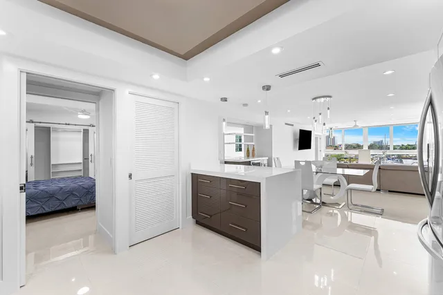 a kitchen with stainless steel appliances kitchen island granite countertop a refrigerator and cabinets