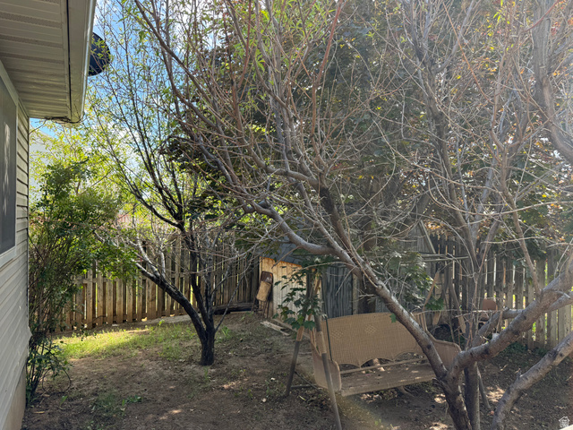 44 Wapiti Loop Hyrum, UT 84319 - Photo 3 of 18 Private backyard featuring a wooden privacy fence, mature trees, and a storage shed