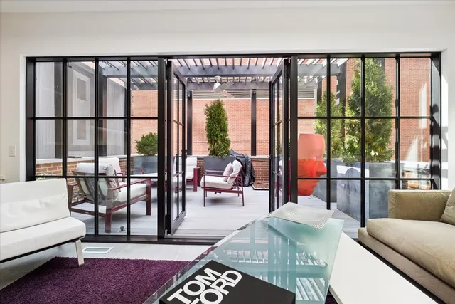 a living room with furniture and a floor to ceiling window
