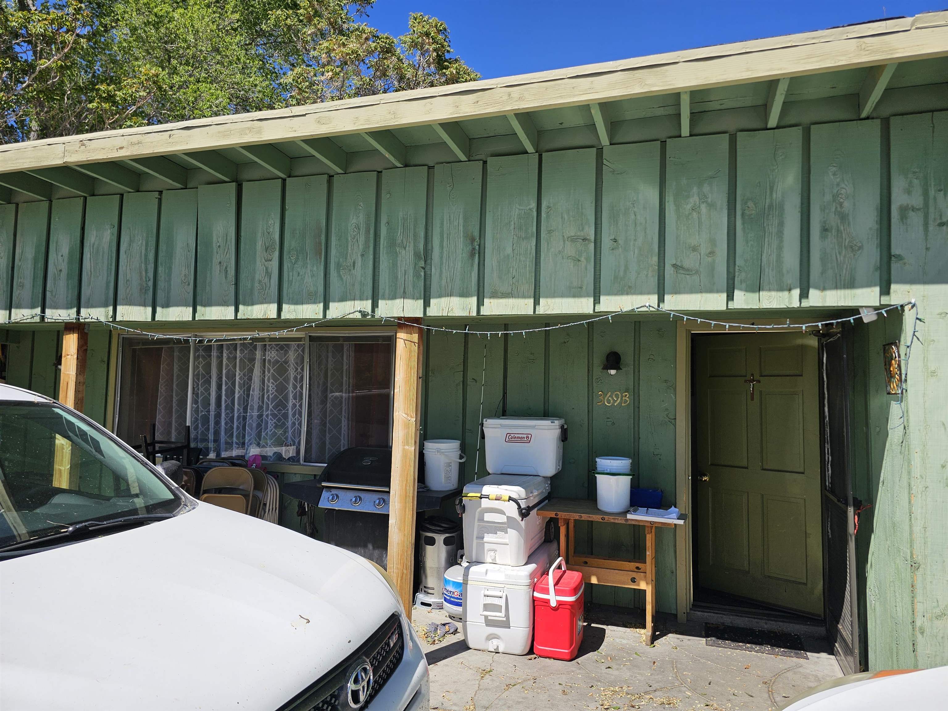 363 Short Street Bishop, CA 93514 - Photo 13 of 17 Exterior entry featuring vertical wood siding, a paneled door, and exposed rafter tails