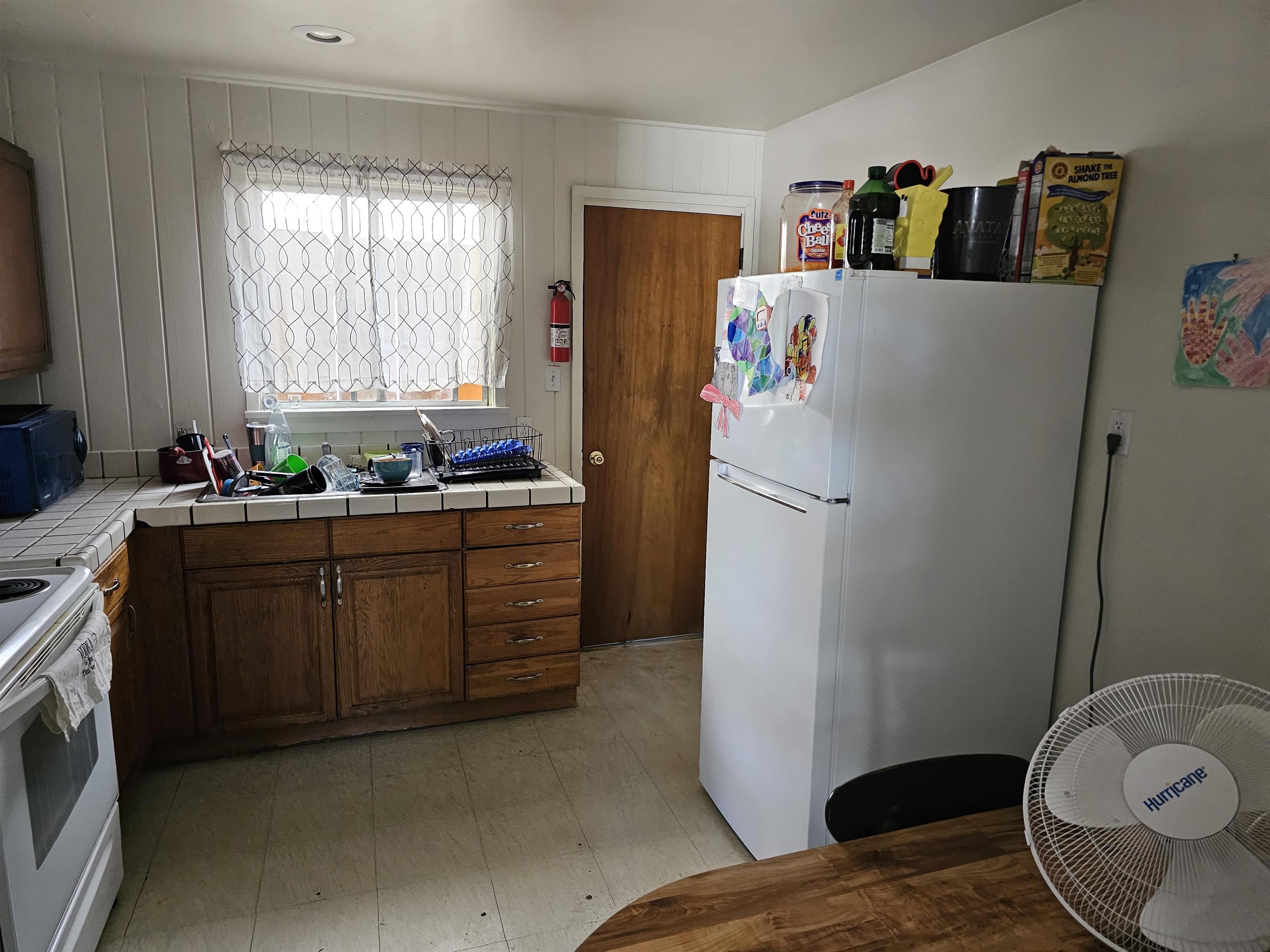 363 Short Street Bishop, CA 93514 - Photo 17 of 17 Kitchen area featuring wood cabinetry, white tiled countertops, and a double-hung window
