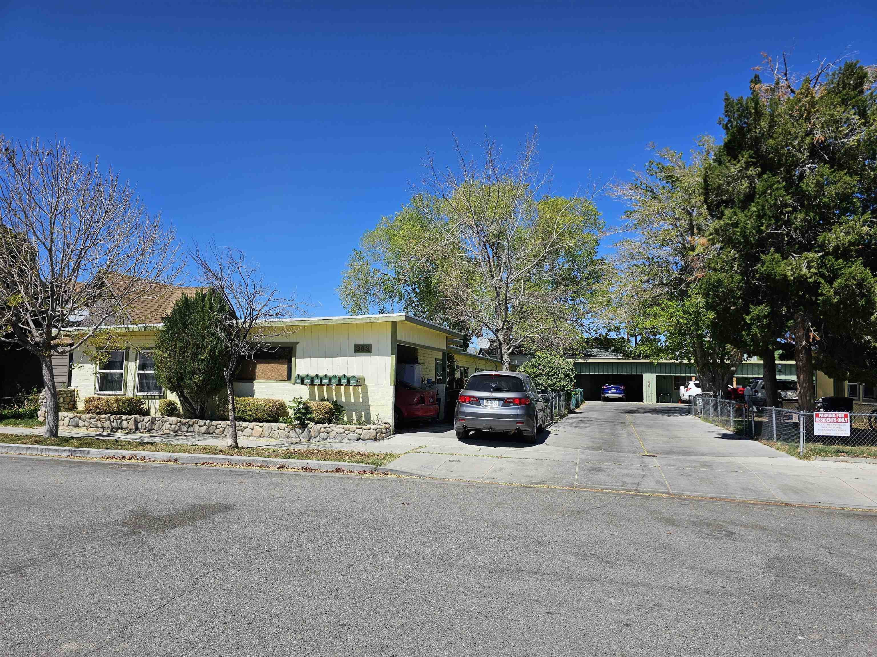 363 Short Street Bishop, CA 93514 - Photo 2 of 17 Front exterior with a light-colored siding facade, multiple windows, and a stone-clad planter box