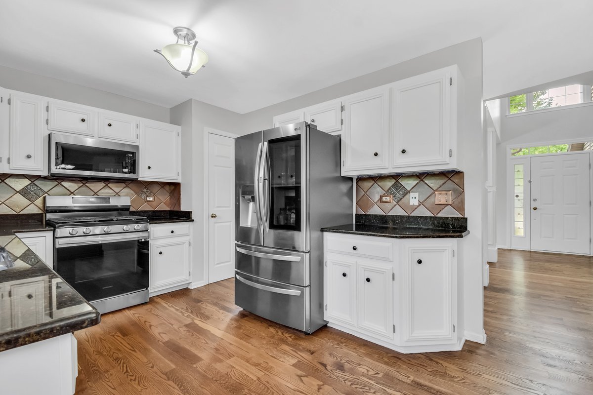 3420 Parliament Lane Naperville, IL 60564 - Photo 14 of 47 a kitchen with stainless steel appliances a stove a microwave and white cabinets
