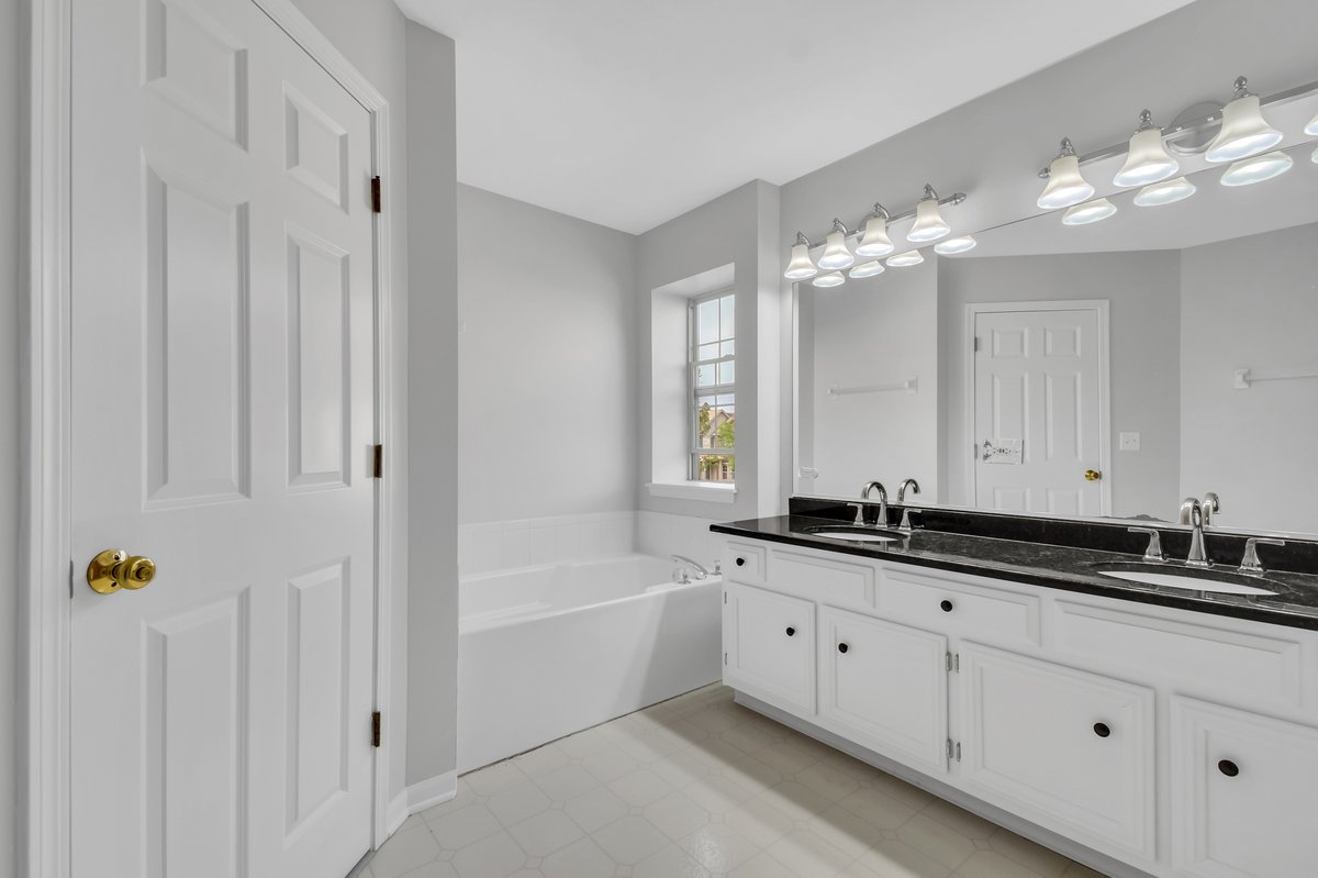 3420 Parliament Lane Naperville, IL 60564 - Photo 23 of 47 a bathroom with a granite countertop sink a large mirror and a bathtub