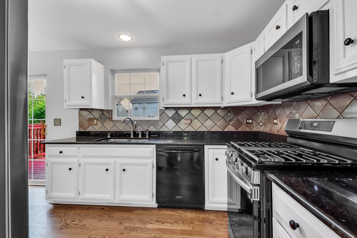 3420 Parliament Lane Naperville, IL 60564 - Photo 5 of 47 a kitchen with granite countertop white cabinets and stainless steel appliances