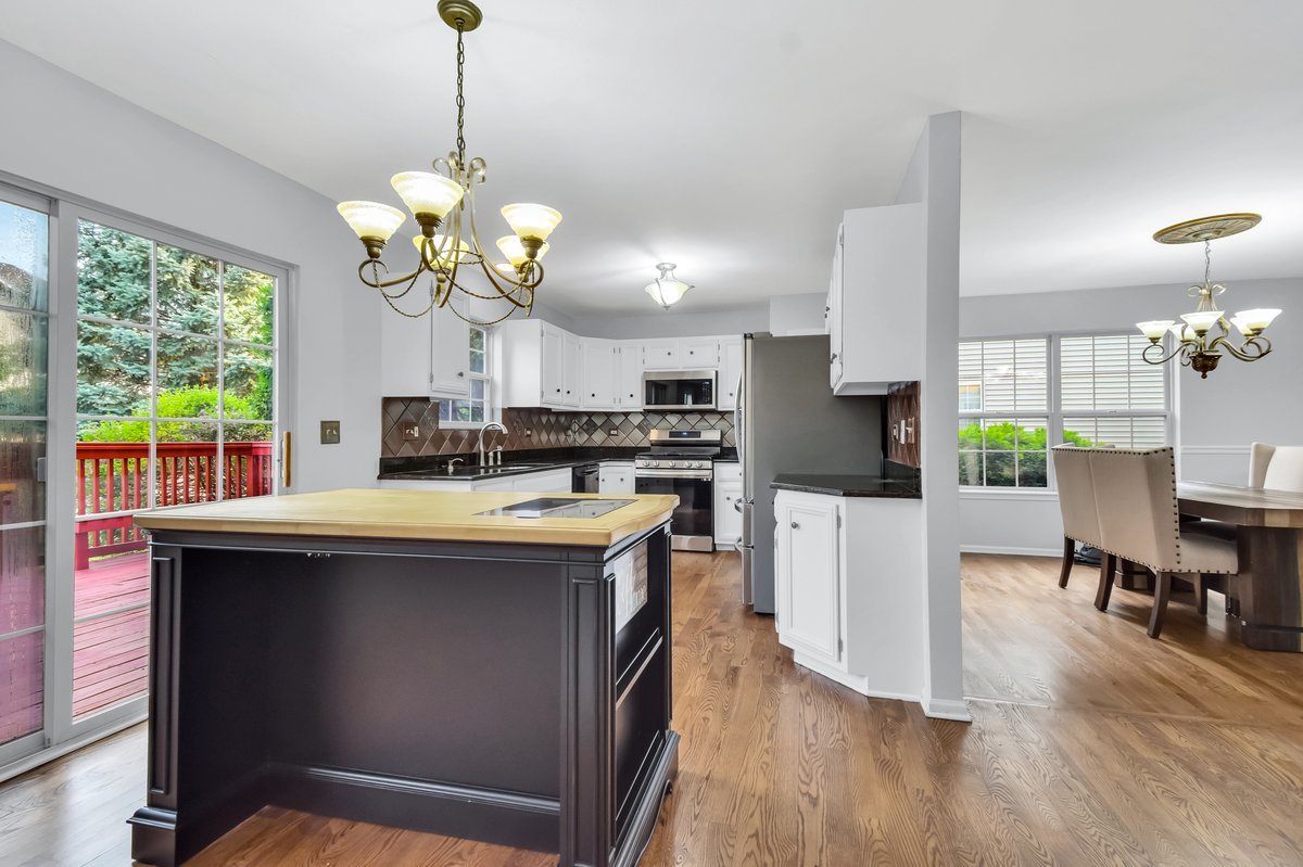 3420 Parliament Lane Naperville, IL 60564 - Photo 6 of 47 a kitchen with stainless steel appliances granite countertop a stove a refrigerator a sink dishwasher a dining table and chairs with wooden floor