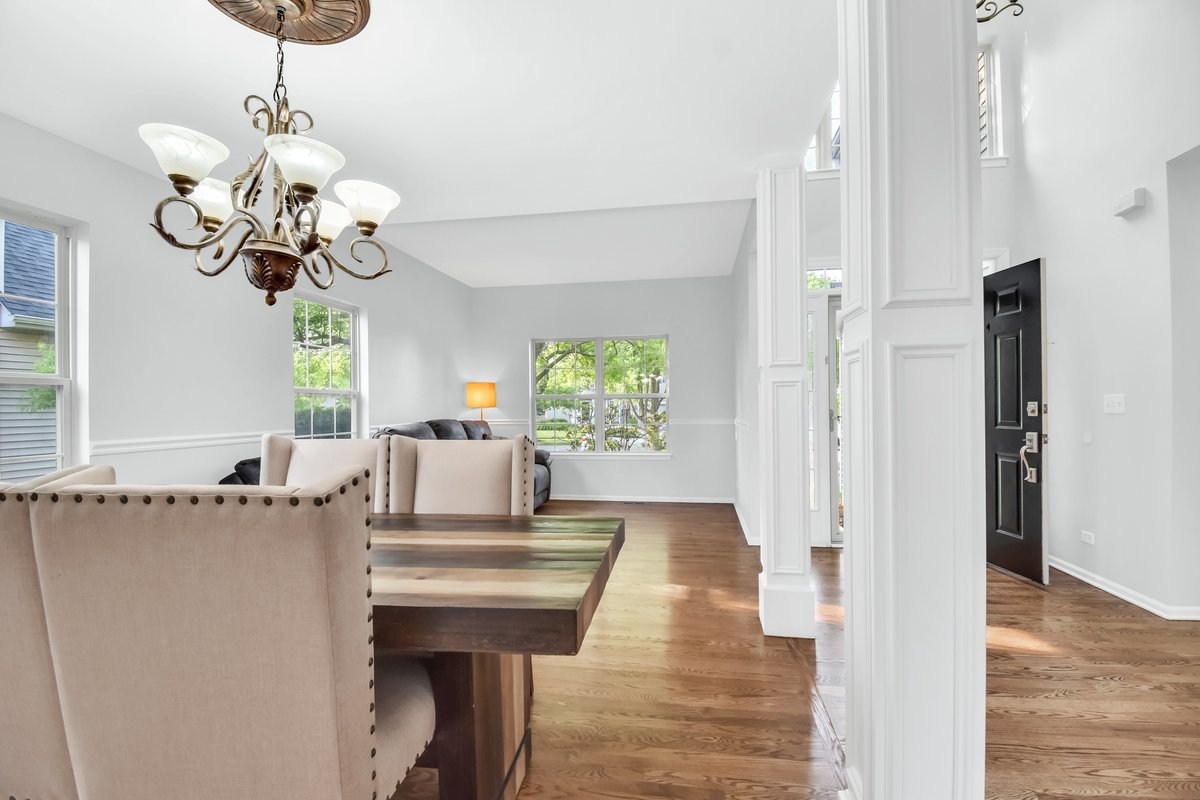3420 Parliament Lane Naperville, IL 60564 - Photo 7 of 47 a dining room with wooden floor a chandelier a wooden table and chairs