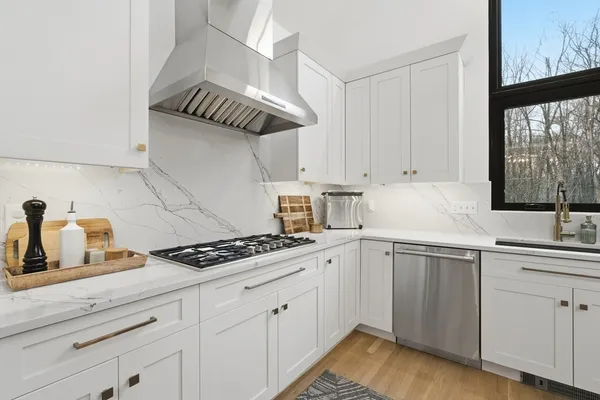 a kitchen with granite countertop a sink stove and cabinets