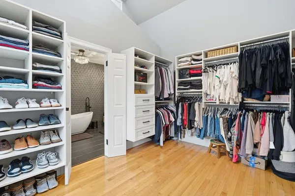 a view of walk in closet with clothes and shoes