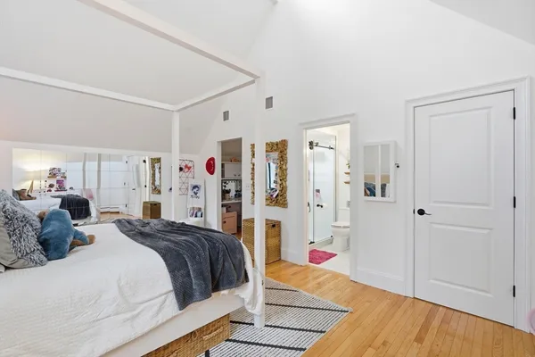 a bedroom with a bed and a wooden floor