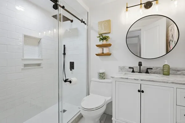 a bathroom with a granite countertop sink toilet and shower