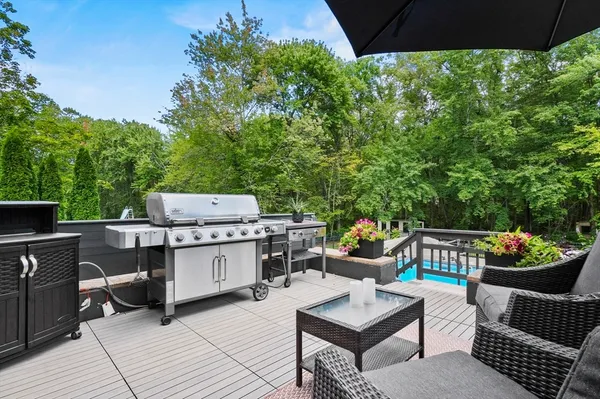 a backyard of a house with barbeque oven table and chairs