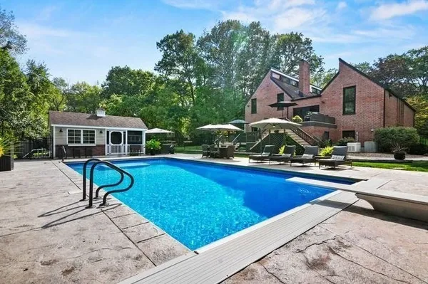 a view of a house with swimming pool and sitting area