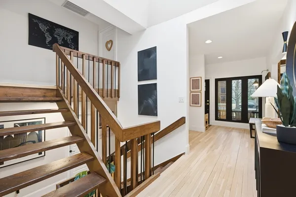 a view of staircase with lots of frames on wall and a dining table