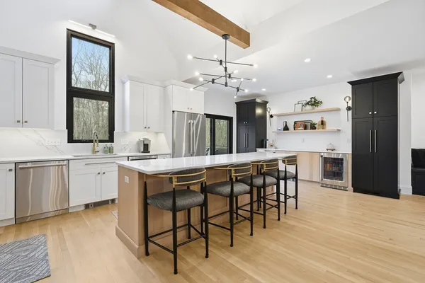 a kitchen with stainless steel appliances kitchen island granite countertop a table chairs sink and cabinets