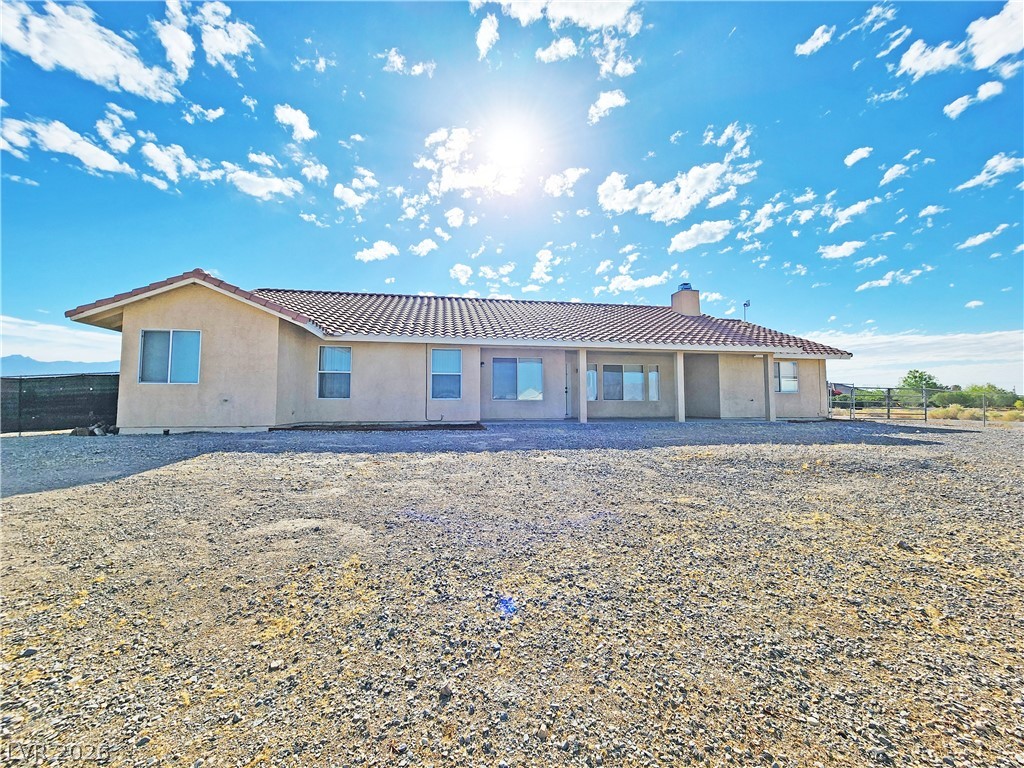 3680 Ravine Avenue Pahrump, NV 89048 - Photo 27 of 28 View of front facade with fence, a chimney, and stucco siding