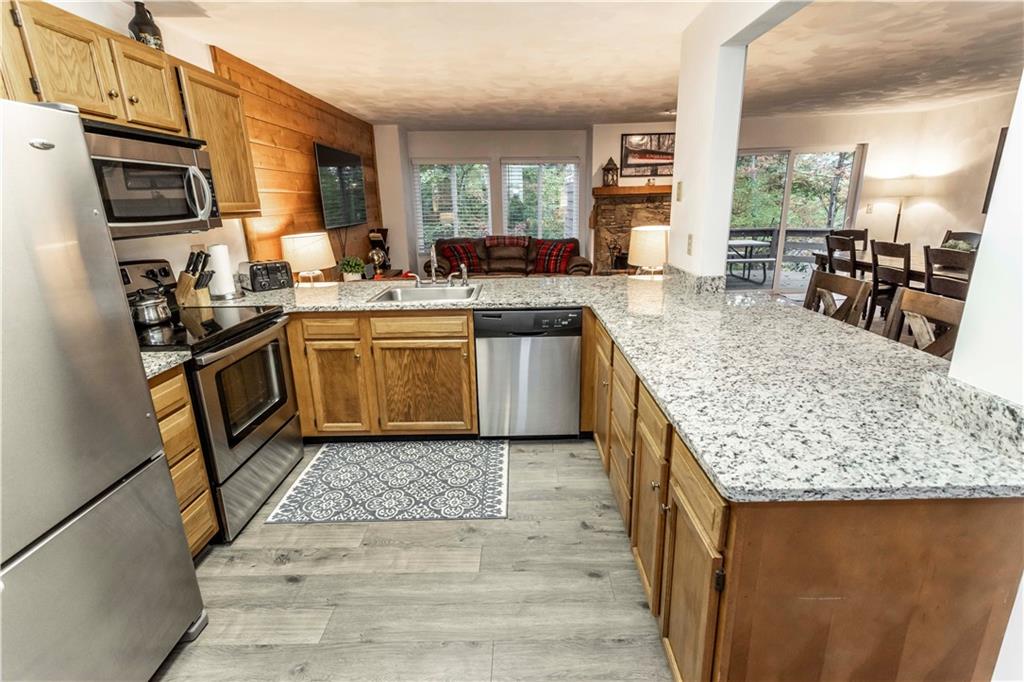 1821 Eagles Ridge Terrace Hidden Valley, PA 15502 - Photo 18 of 49 a kitchen with stainless steel appliances granite countertop a stove top oven a sink dishwasher and cabinets with wooden floor