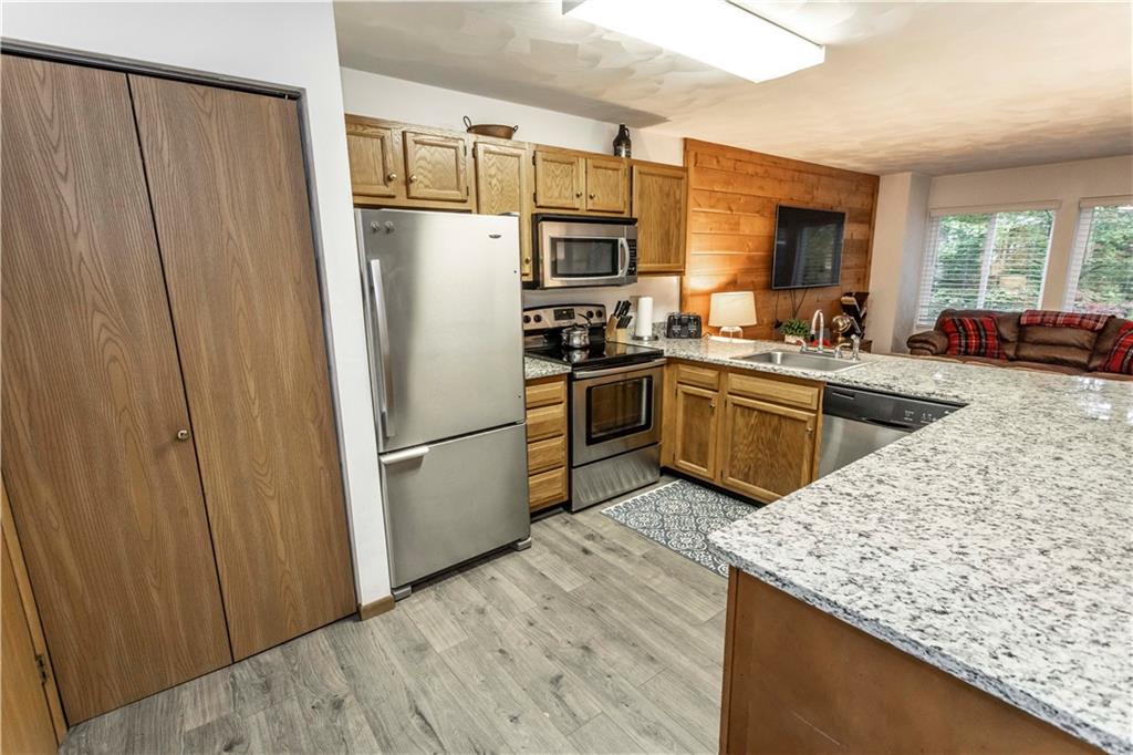 1821 Eagles Ridge Terrace Hidden Valley, PA 15502 - Photo 19 of 49 a kitchen with stainless steel appliances granite countertop a refrigerator a sink dishwasher a stove with wooden cabinets and floor
