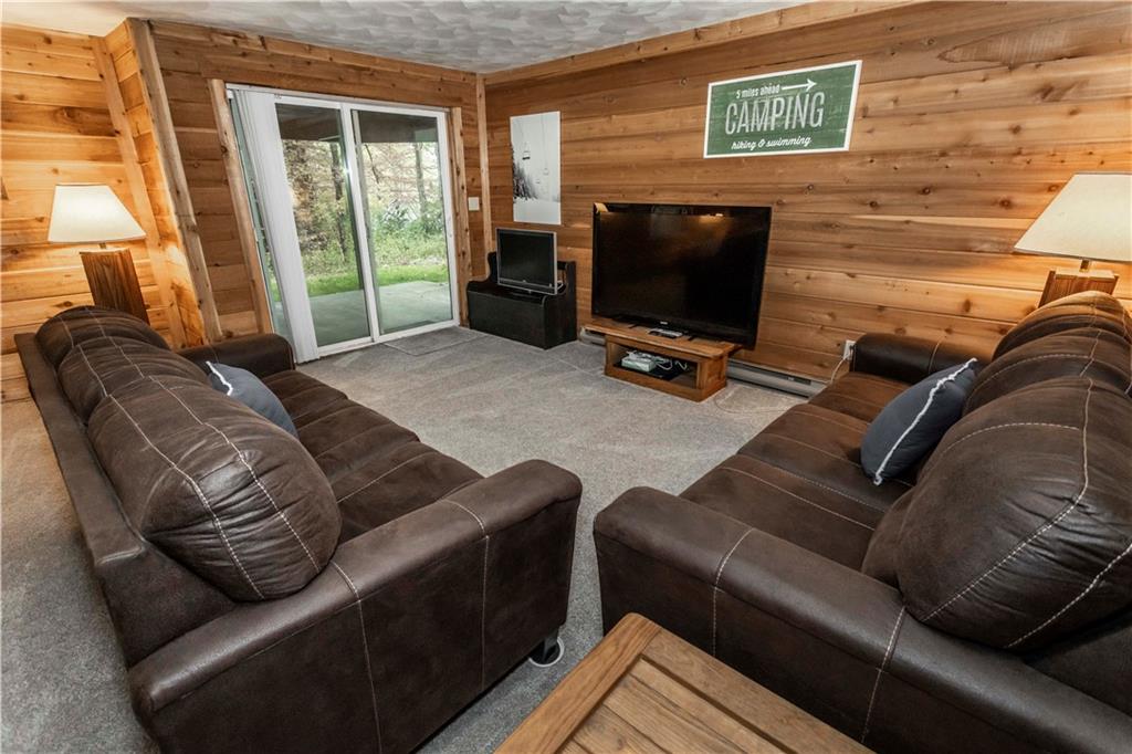 1821 Eagles Ridge Terrace Hidden Valley, PA 15502 - Photo 29 of 49 a living room with furniture a flat screen tv and a floor to ceiling window