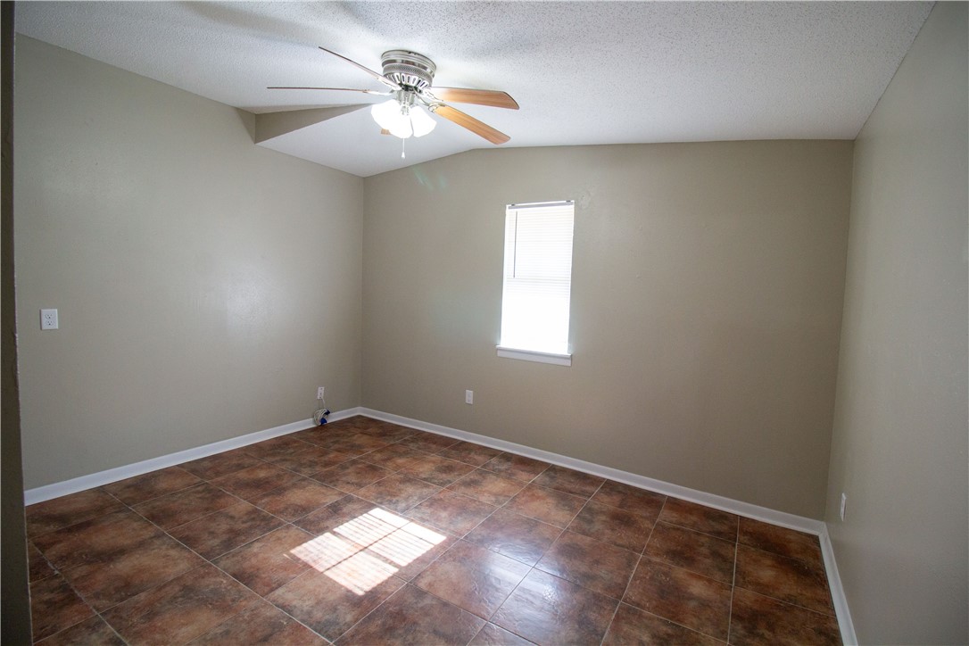 1804 North McKinley Street Beeville, TX 78102 - Photo 13 of 15 an empty room with windows and chandelier fan