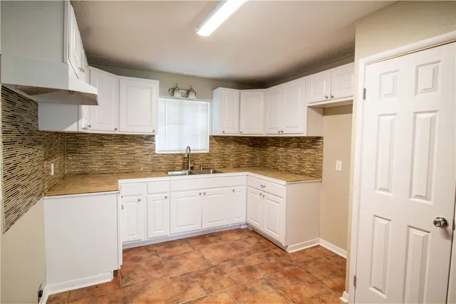 a kitchen with granite countertop white cabinets and stainless steel appliances