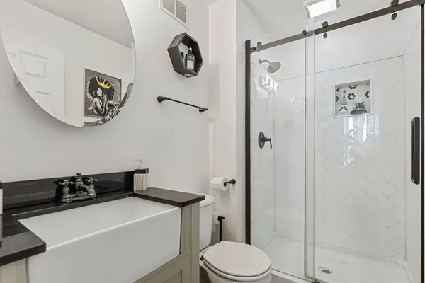 a bathroom with a sink a toilet and shower