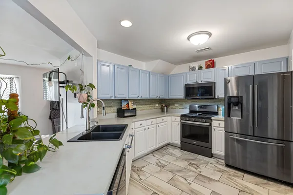 a kitchen with a sink a refrigerator and a stove top oven