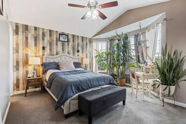 a spacious bedroom with a balcony a large bed and a chandelier