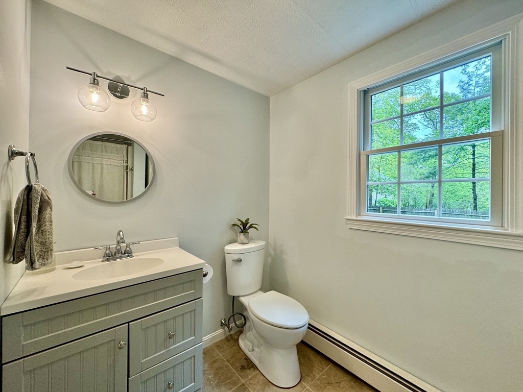 29 Whitewood Road Groton, MA 01450 - Photo 19 of 38 a bathroom with a toilet a sink a mirror and window