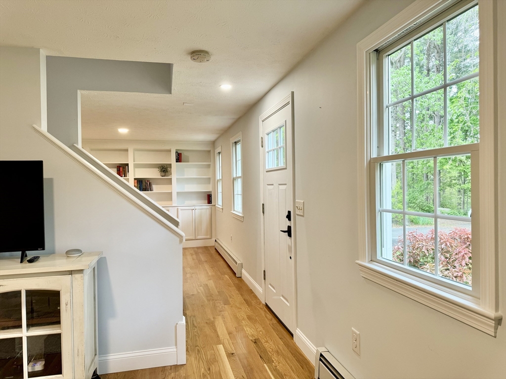 29 Whitewood Road Groton, MA 01450 - Photo 3 of 38 a view of a hallway with wooden floor and windows