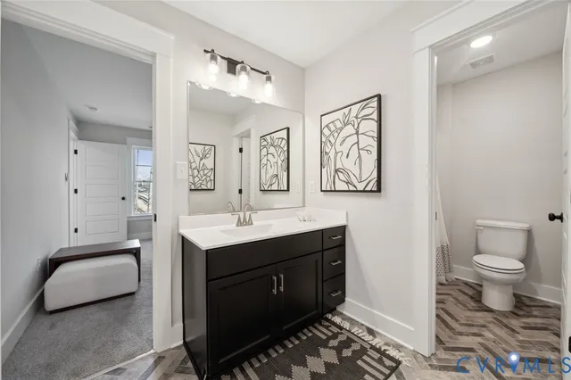 a spacious bathroom with a toilet sink and mirror