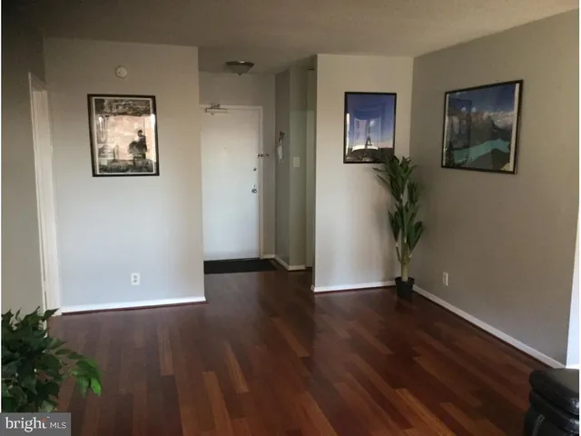 a view of empty room with wooden floor and window