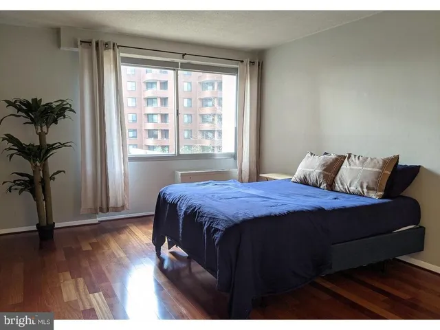 a bedroom with a bed and a wooden floor