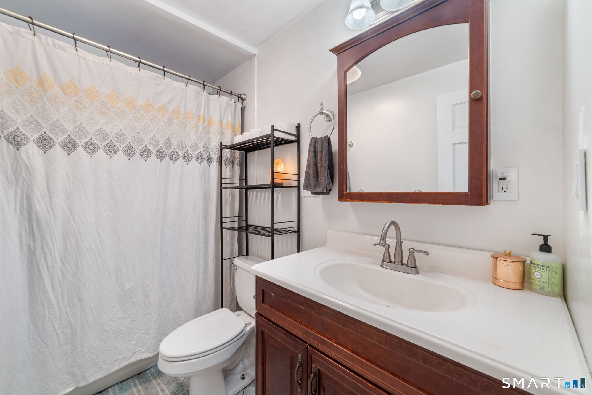 25 High Street Windsor, CT 06095 - Photo 20 of 40 a bathroom with a sink a toilet and shower curtain