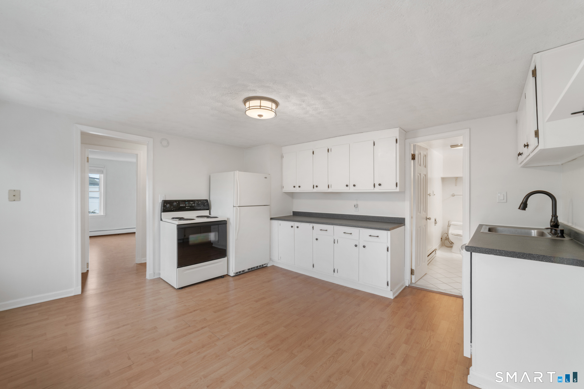 25 High Street Windsor, CT 06095 - Photo 25 of 40 a kitchen with granite countertop white cabinets and stainless steel appliances