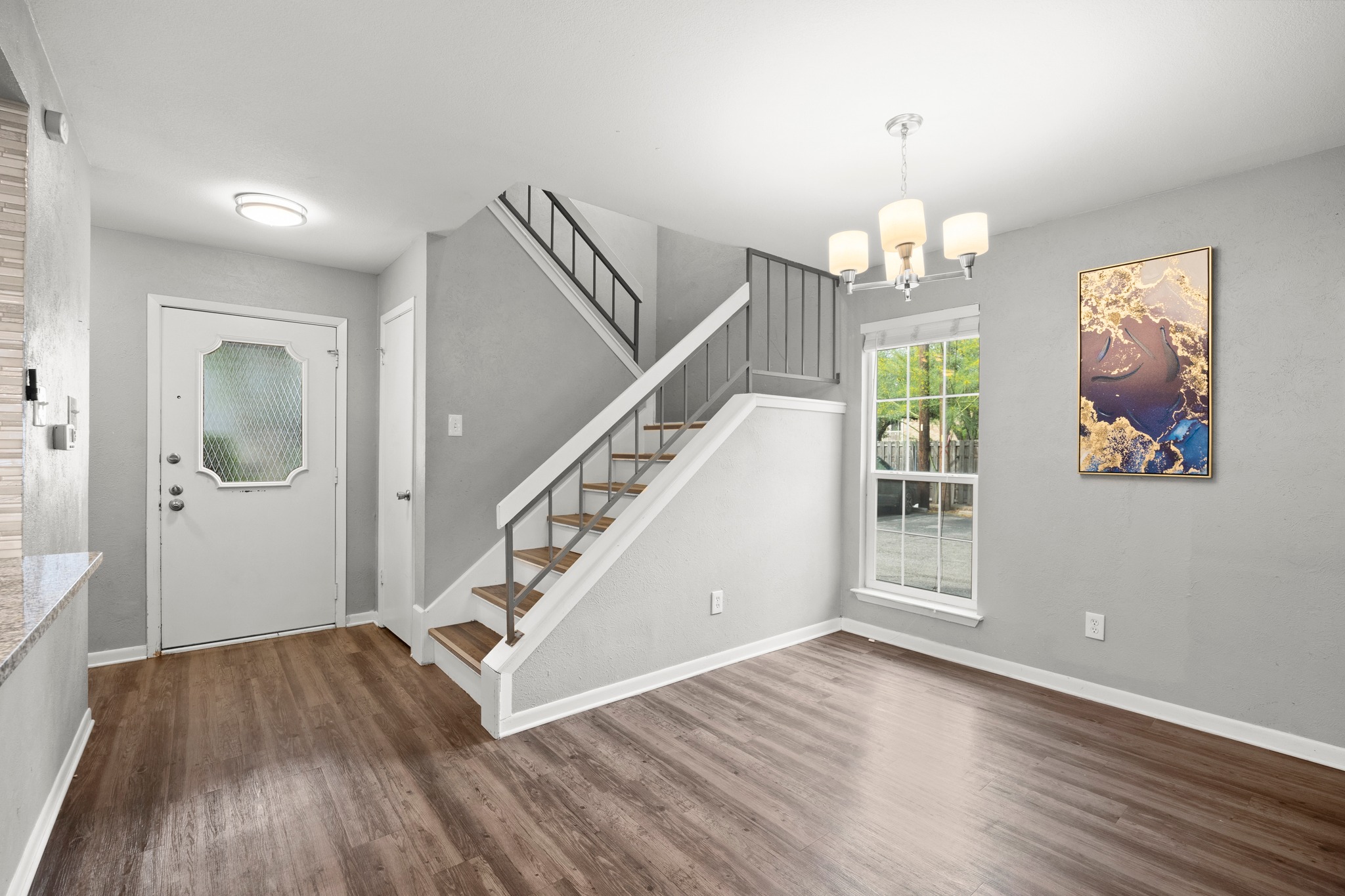 8330 Fathom Circle, Unit 501 Austin, TX 78750 - Photo 3 of 26 wooden floor with an entryway and chandelier in living room