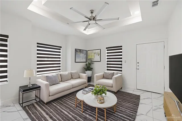 a living room with furniture a chandelier and a dining table with wooden floor