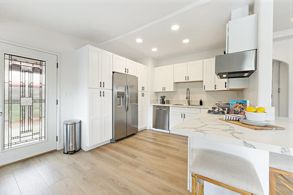 a kitchen with stainless steel appliances a refrigerator sink and wooden cabinets