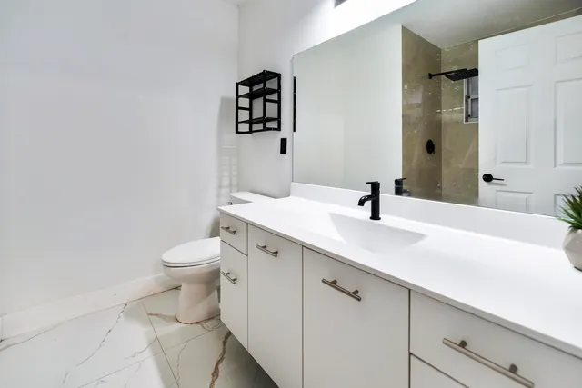 a bathroom with a sink toilet and shower