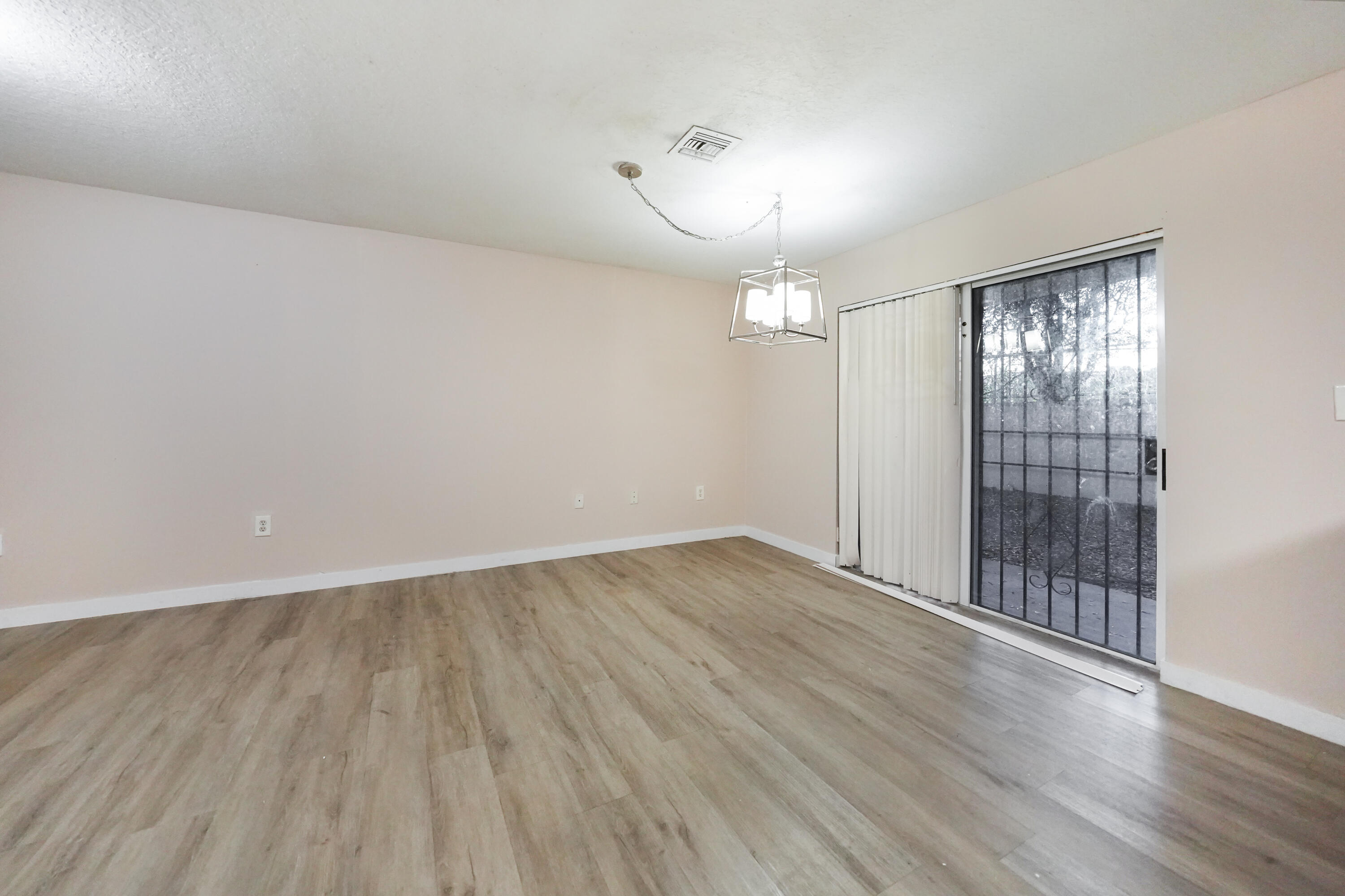 14142 Southwest 260th Street, Unit 105 Homestead, FL 33032 - Photo 2 of 17 wooden floor in an empty room with a window