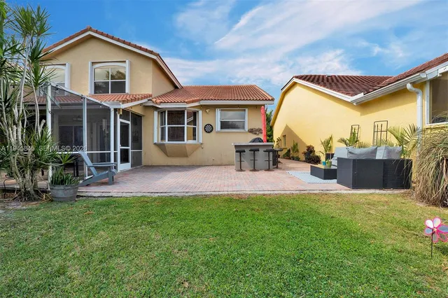 a view of a house with a yard and sitting area