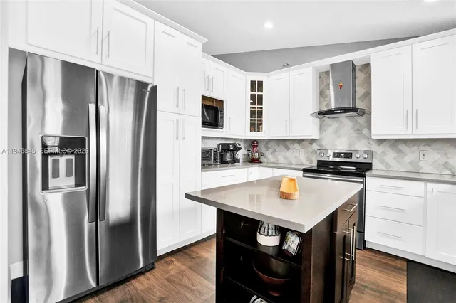 a kitchen with stainless steel appliances granite countertop a refrigerator stove and sink