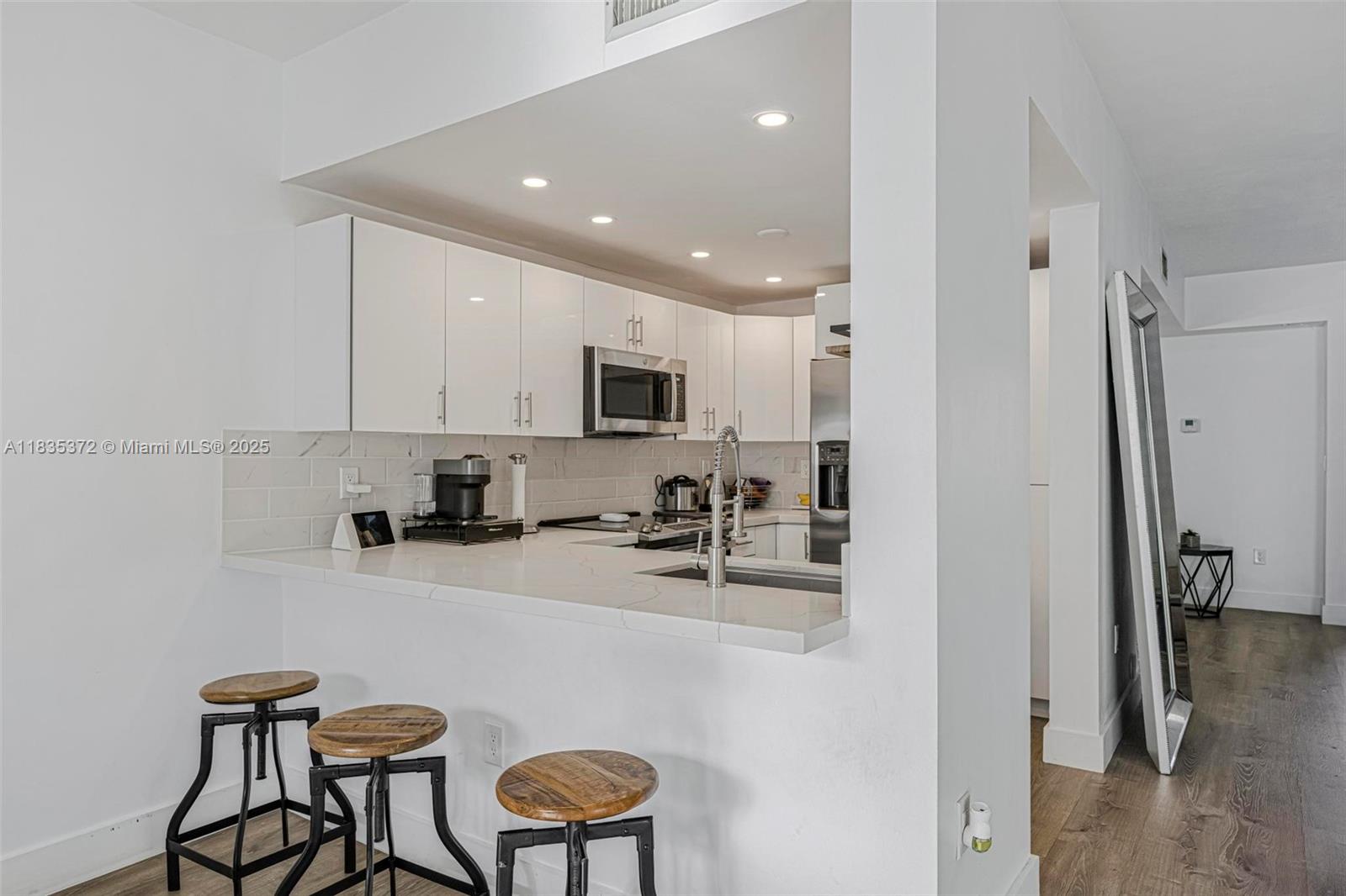 11532 Southwest 148th Path Miami, FL 33196 - Photo 11 of 36 a kitchen with white cabinets and stainless steel appliances