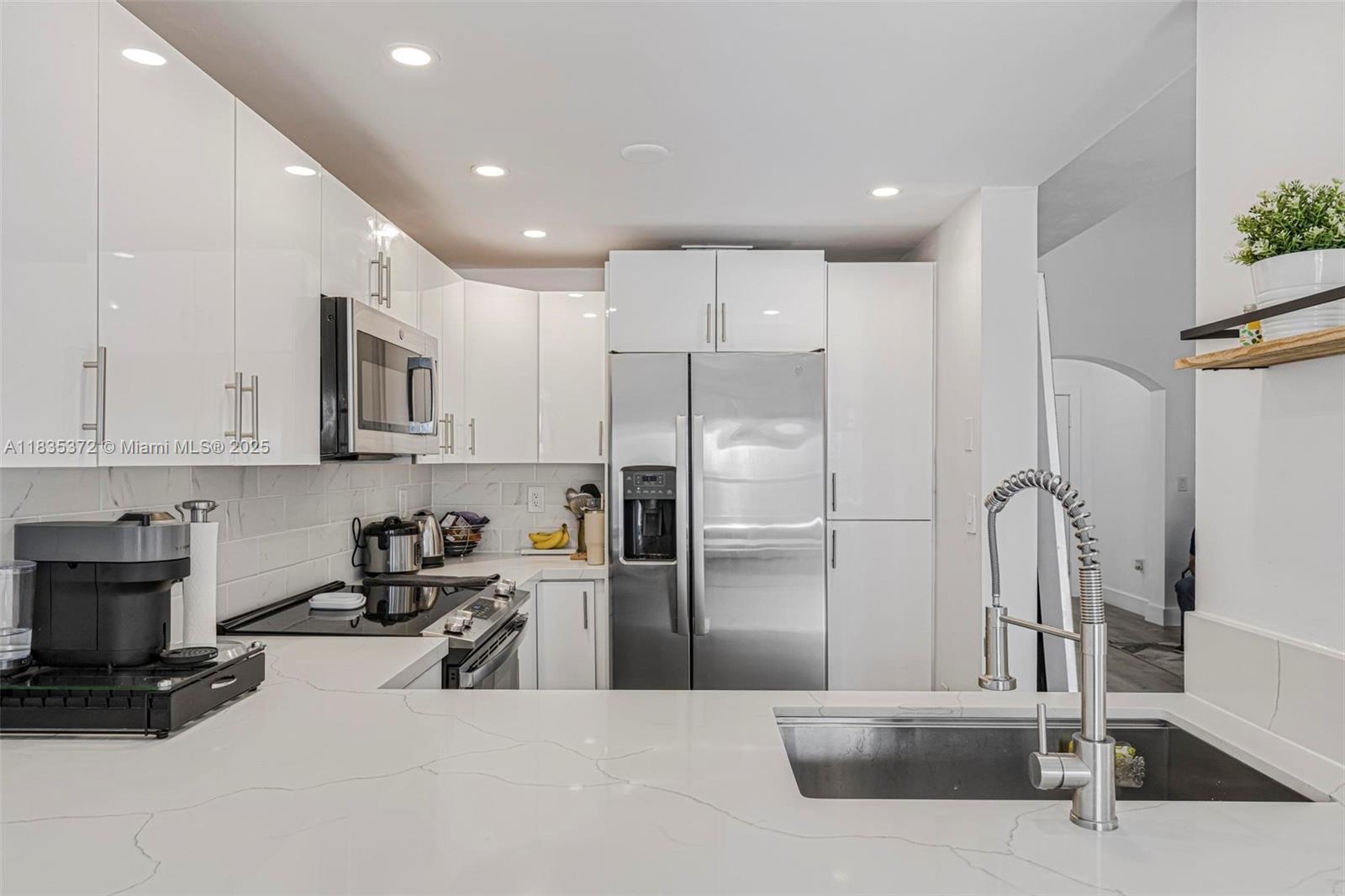11532 Southwest 148th Path Miami, FL 33196 - Photo 12 of 36 a kitchen with stainless steel appliances granite countertop a refrigerator a sink a stove and a refrigerator with wooden floor